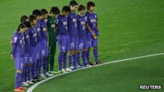 Players of the Japanese team Sanfrecce Hiroshima observe a minute's silence at football's Club World Cup on Thursday