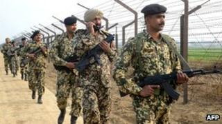 Indian Border Security Force soldiers patrol along the India-Pakistan border fence about 27 KM from Wagah on January 13, 2013