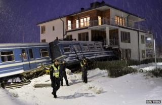 Police guard the scene where a train hit a house in a Stockholm suburb, 15 January