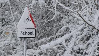 School sign covered in snow