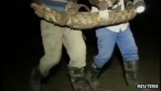 Screengrab from Reuters showing workers at the Rakwena Crocodile Farm with a captured crocodile