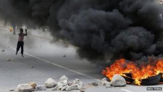 A child runs towards a burning barricade during a strike by farm workers at De Doorns in South Africa on 9 January 2013