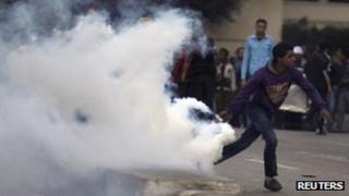 A protester throws a teargas canister in Cairo. Photo: 7 March 2012