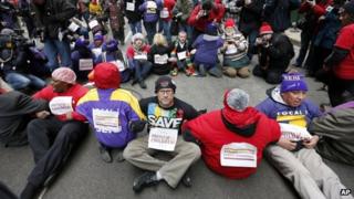 Protesters sit on LaSalle Street during an act of civil disobedience in Chicago, Illinois 27 March 2013