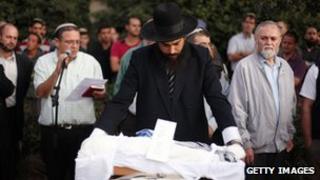 Israeli settlers attend the funeral of Asher Palmer and his infant son, Yonatan, on 25 September 2011, near the West Bank town of Hebron.