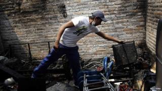 A resident combs through the remains of his home in Ecatpec, Mexico, on 7 May 2013