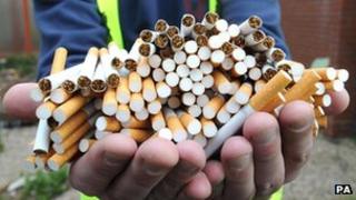A pair of hands holding a large amount of cigarettes