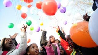 Kids release balloons after a prayer for former South African President Nelson Mandela on July 5, 2013 outside the Medi Clinic Heart Hospital where Mandela is hospitalized in Pretoria.