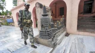 An Indian security personnel walks next to bloody footprints inside the Mahabodhi temple complex, after a series of explosions at Bodh Gaya in the eastern Indian state of Bihar July 7, 2013