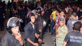 Egyptian police officers confronting a crowd in Mansoura