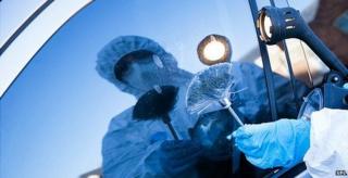 Forensics officer dusting for fingerprints