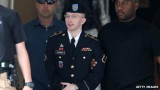US Army Private First Class Bradley Manning is escorted by military police as he leaves his military trial after he was found guilty of 20 charges 20 July 2013