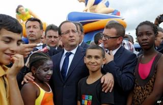 French President Francois Hollande (centre) meets people in Clichy-Sous-Bois, near Paris, 31 July