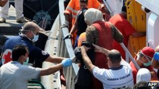 Migrants being helped ashore in Sicily, 19 Aug 13