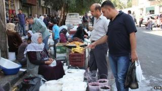 Syrians shop at al-Fahameh market in Damascus