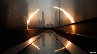 A man runs past the 9/11 Empty Sky memorial at sunrise across from New York's Lower Manhattan and One World Trade Center in Liberty State Park in Jersey City, New Jersey, on 11 September 2013