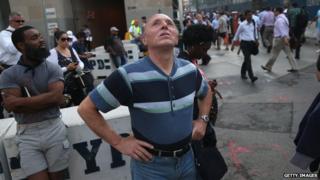 A man gazes at the One World Trade Center as church bells toll for 9/11 victims on 11 September 2013