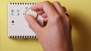 Hand on thermostat