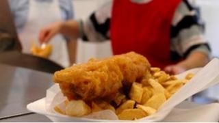 Fish and chips being served in a traditional British fish and chip shop