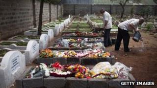 A cemetery worker washes his hands next to five fresh graves in Nairobi