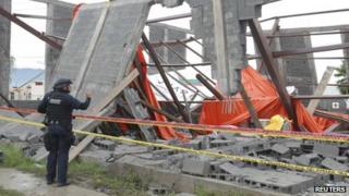 A federal police officer takes a photograph at the collapsed Santa Clara Catholic Church on 29 September, 2013