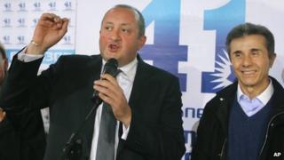 Georgia's Prime Minister Bidzina Ivanishvili, right, and presidential candidate Giorgi Margvelashvili, left, greet supporters at the Georgian Dream coalition headquarters in Tbilisi, Georgia (27 Oct. 2013)