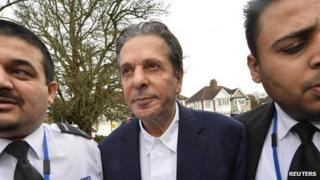 Charles Saatchi arrives at court flanked by two security men