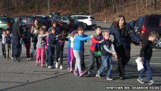 Connecticut State Police lead a line of children from the Sandy Hook Elementary School in Newtown, Connecticut, on 14 December 2012