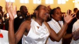 Member of a local choir sing and dance during a memorial service for Nelson Mandela at the Komkhulu or "Great Place" in Mvezo.