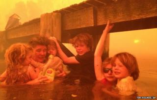 For three hours, Tim Holmes and his family sought refuge in neck-deep water under a jetty near the town of Dunalley.