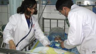 In this photo taken on Friday 13 December, medical workers attend to a child recovering from a serious adverse reaction to a hepatitis B vaccination in a hospital in Changde City, Hunan province.