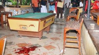 Members of the public view some blood stains on the floor next to a pool table at the Tanduri Bar and Night Club in Ukunda which is 40km south of Kenya"s coastal town of Mombasa.,
