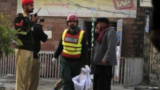 A rescue worker collects evidence from the site of a suicide blast in Rawalpindi, 20 January 2014