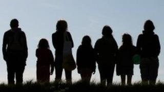 Silhouettes of a group of people in a line