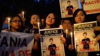 Indian students from the northeastern states and supporters hold placards and lit candles as they protest the death of northeastern student Nido Tania in New Delhi on February 2, 2014