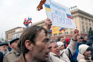 A woman holds up a banner saying "Protect me Russia" at a protest in Kharkiv (5 March 2014)
