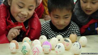 Children balance eggs on a table