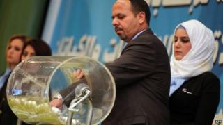 Members of Iraq's Independent High Electoral Commission (IHEC) choose ballot numbers for the blocs competing in April's elections (29 January 2014)