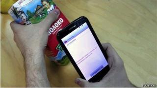 A man uses the Boycott the Occupiers app to see where a packet of milk has come from