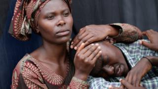 A woman consoles a 22-year-old man during the 20th anniversary commemoration of the 1994 genocide at Amahoro Stadium7 April 2014 in Kigali, Rwanda