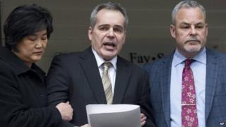 Douglas de Grood, centre, is supported by wife Susan, left, and lawyer Allan Fay after reading a statement in Calgary, Canada 17 April 2014