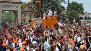 BJP's PM candidate Narendra Modi (C) gestures to supporters during a rally in Varanasi on April 24, 2014
