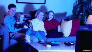 Family on a sofa watching television