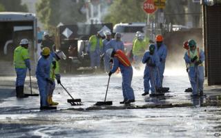 Workers clear up oil
