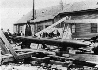 Torpedo lying in street amid damage