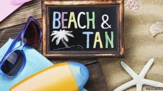 A sign on the beach saying "Beach & Tan"