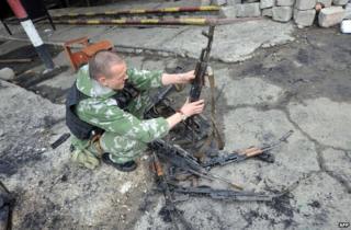 A rebel fighter examines abandoned guns inside the captured National Guard base in Luhansk, Ukraine, 4 June