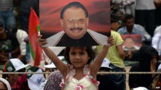 A young girl from Pakistan's Muttahida Qaumi Movement (MQM) party holds a photograph of party leader Altaf Hussain