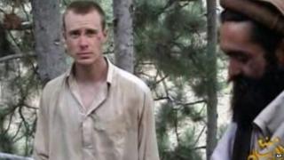 This file image provided by IntelCenter shows a frame grab from a video released by the Taliban containing footage of a man believed to be Bowe Bergdahl, left. 8 December 2010