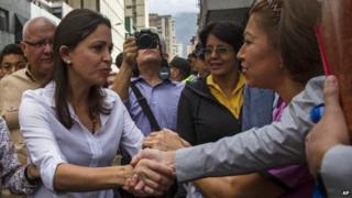 Maria Machado shakes hand with supporter in Caracas